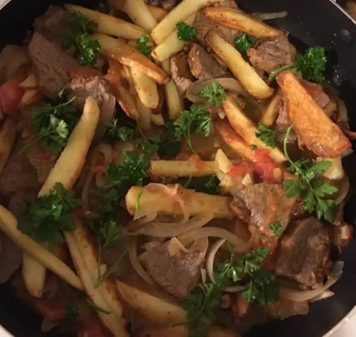 Delicious Chicken Lomo Saltado in a traditional Peruvian style, served with rice and fries