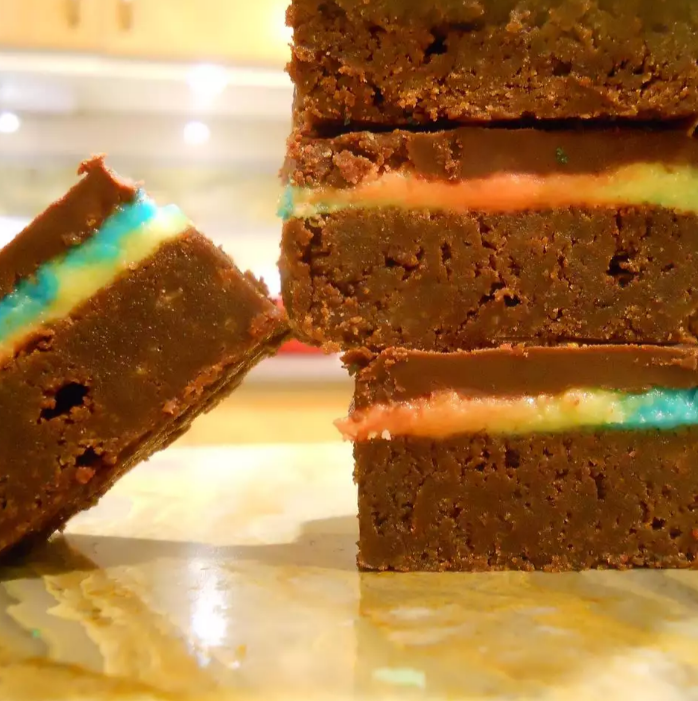 Freshly baked easy red velvet brownies with creamy frosting on a cooling rack